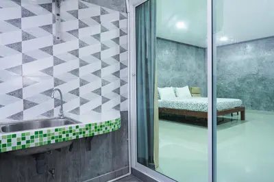 a bathroom with a sink and a shower with a bed at Guesthouse Phuket Airport in Ban Bo Han