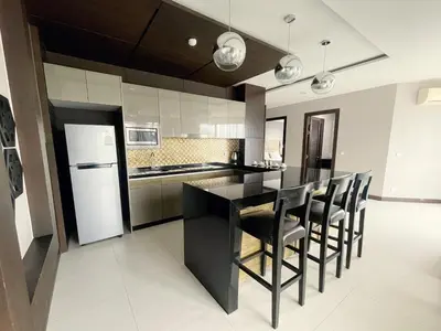 a kitchen with a black counter and black chairs at The Regent Bangtao Apartments in Bang Tao Beach
