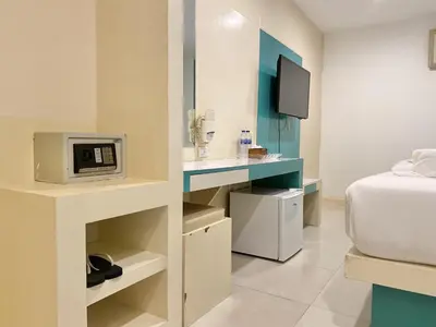 a small room with a bed and a microwave at Patong Platinum in Patong Beach