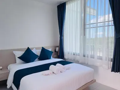 two beds in a hotel room with towels on them at White Seaview Residence in Klong Muang Beach