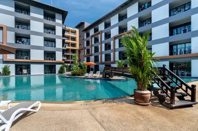 a swimming pool in front of a building at Tuana Hotels Casa Del Sol in Kata Beach