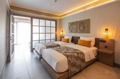 a hotel room with two beds and a window at Tuana Hotels Casa Del Sol in Kata Beach