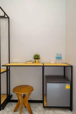 a desk with a stool and a table with a plant at Terminal 58 Airport in Ban Mut Dok Khao