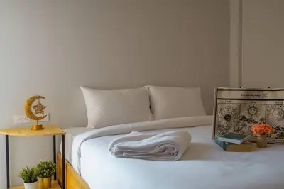 a white bed with a blanket on top of it at Terminal 58 Airport in Ban Mut Dok Khao