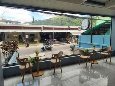 a restaurant with two tables and chairs and a window at THE NICE in Patong Beach
