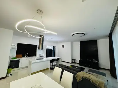 a kitchen and living room with a table and a chandelier at Sunrise Ocean Villa 20 in Phuket Town