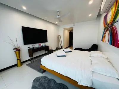 a bedroom with a large bed and a flat screen tv at The Sunrise Ocean Villa 22 in Phuket Town