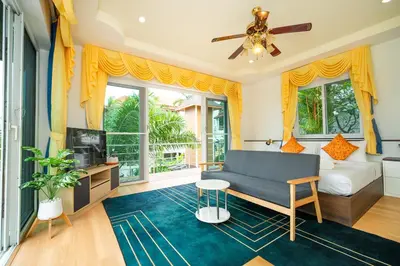 a living room with a couch and a tv at ฺBaan Waru seaview villa in Kata Beach