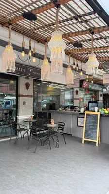 a restaurant with tables and chairs and chandeliers at Talya Patong Hotel in Patong Beach