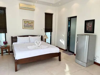 a bedroom with a bed and a refrigerator in it at Maya Villa by G Estate in Rawai Beach