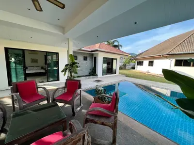 a patio with chairs and a swimming pool at Maya Villa by G Estate in Rawai Beach