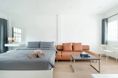 a bedroom with a bed and a couch at White House Apartment - Chalong in Chalong