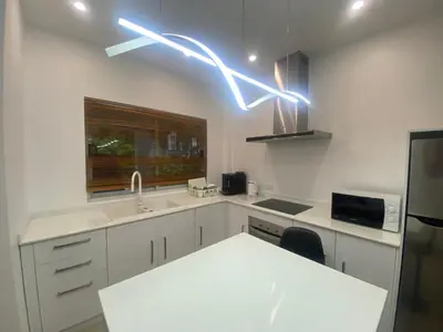 a kitchen with white cabinets and a sink and lights at Seaview Prima Villa Karon beach in Karon Beach