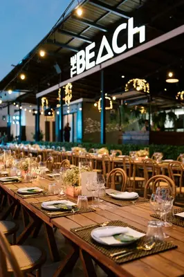 a long wooden table with plates and wine glasses at VARANA Krabi Hotel in Klong Muang Beach