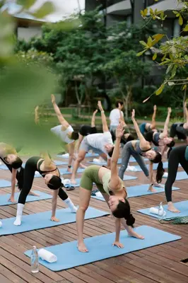 a group of people doing a yoga pose on mats at VARANA Krabi Hotel in Klong Muang Beach
