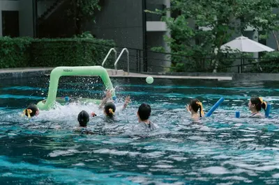a group of people playing in a swimming pool at VARANA Krabi Hotel in Klong Muang Beach