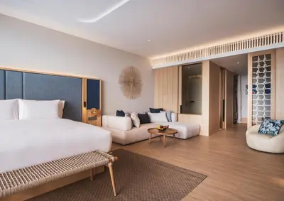 a bedroom with a large bed and a living room at Anantara Koh Yao Yai Resort & Villas in Ko Yao Yai