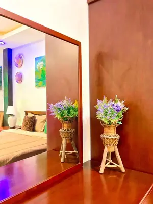 a mirror and two vases with flowers in a room at Sea Smile Green View Pool Villa KRABI Klong Muang in Klong Muang Beach