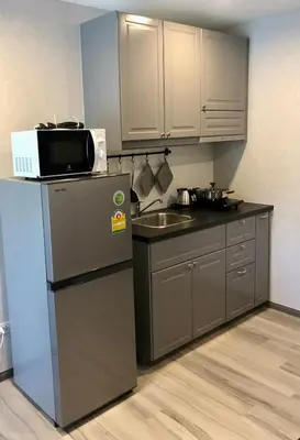a kitchen with a microwave on top of a refrigerator at Nai Yang Beach Holiday Rental Apartement - Title Residence in Nai Yang Beach