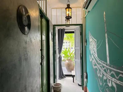 a hallway with a door open to a room at Auntie & Niece PHUKET in Ban Sam Kong