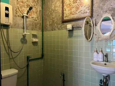 a green tiled bathroom with a sink and a shower at Auntie & Niece PHUKET in Ban Sam Kong