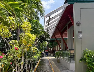 a building with a porch with a bunch of plants at Kata Forte Resort in Kata Beach