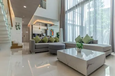 a living room with a couch and a table at Panora villa by VillaCarte in Surin Beach