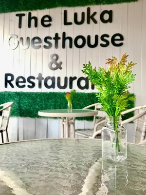 a table with a glass vase with plants on it at The Luka Guesthouse in Patong Beach