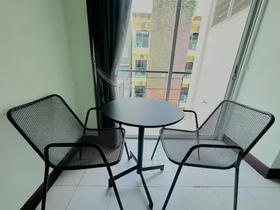 a table and chairs in a room with a window at Cocoon Omaya Guest House in Patong Beach