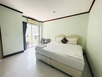 a bedroom with a large bed and a large window at Cocoon Omaya Guest House in Patong Beach