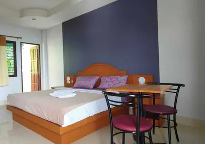a bedroom with a bed and a table and chairs at Pailin Hill Hotel in Patong Beach