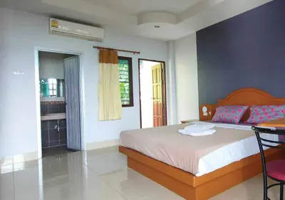 a bedroom with a bed and a table and chairs at Pailin Hill Hotel in Patong Beach