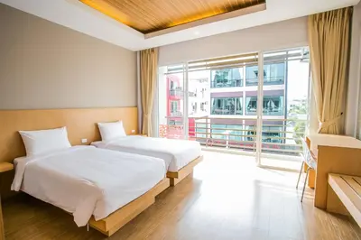 a bedroom with two beds and a large window at Casa De Coral Boutique Hotel in Kata Beach