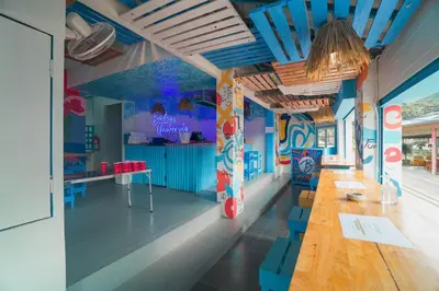 a room with a long table and blue chairs at Bodega Koh Phi Phi in Phi Phi Don