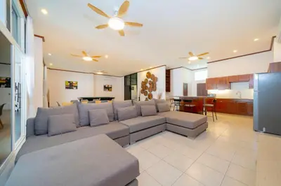 a living room with a couch and a kitchen at Jungceylon Villa - quiet location, pool, maid in Patong Beach