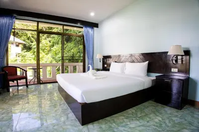 a bedroom with a large bed and a large window at Riviera Patong in Patong Beach