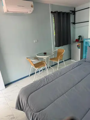 a bedroom with a bed and a table and chairs at Phuketnumnoi23 in Surin Beach