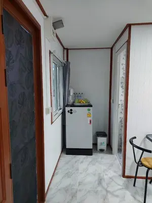 a small kitchen with a white refrigerator in a room at Phuketnumnoi23 in Surin Beach