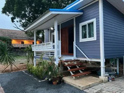 a small blue house with a porch and a bench at Phuketnumnoi23 in Surin Beach