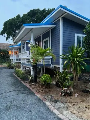 a blue house with palm trees in front of it at Phuketnumnoi23 in Surin Beach