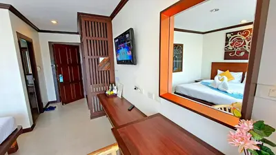 a room with a bed and a large mirror at Southern Comfort Patong in Patong Beach