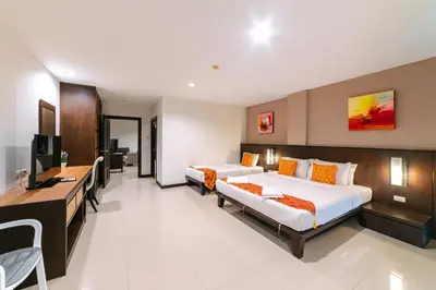 a hotel room with two beds and a television at Ratana Hotel Sakdidet, PHUKET TOWN in Phuket Town