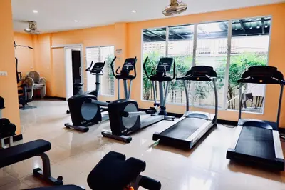 a gym with cardio equipment and a large window at Ratana Residence Thalang in Thalang