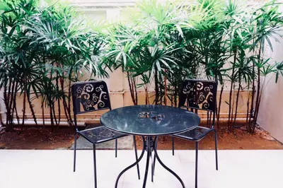 two chairs and a table in front of plants at Ratana Residence Thalang in Thalang