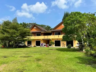 a house with a yard in front of it at Relaxation guesthouse in Thalang