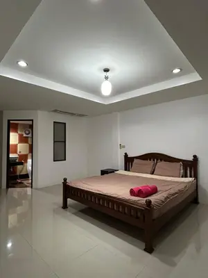 a bedroom with a bed with a red pillow on it at Relaxation guesthouse in Thalang