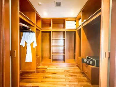 a walk in closet with wooden doors and shelves at 3-4BR Laguna Phuket Golf Course Villa with Pool & Jacuzzi in Laguna Phuket
