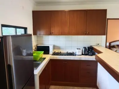 a kitchen with wooden cabinets and a stainless steel refrigerator at Appartamento Patong Beach, all'interno del Sai Rougn residence in Patong Beach