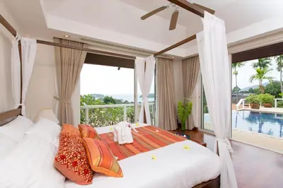 a bedroom with a bed with a view of a pool at Katamanda villa Moon 3 Bed seaview near Kata Beach in Kata Beach