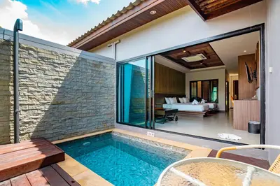 an indoor pool with a view of a house at Malabar Pool Villa Phuket in Phuket Town